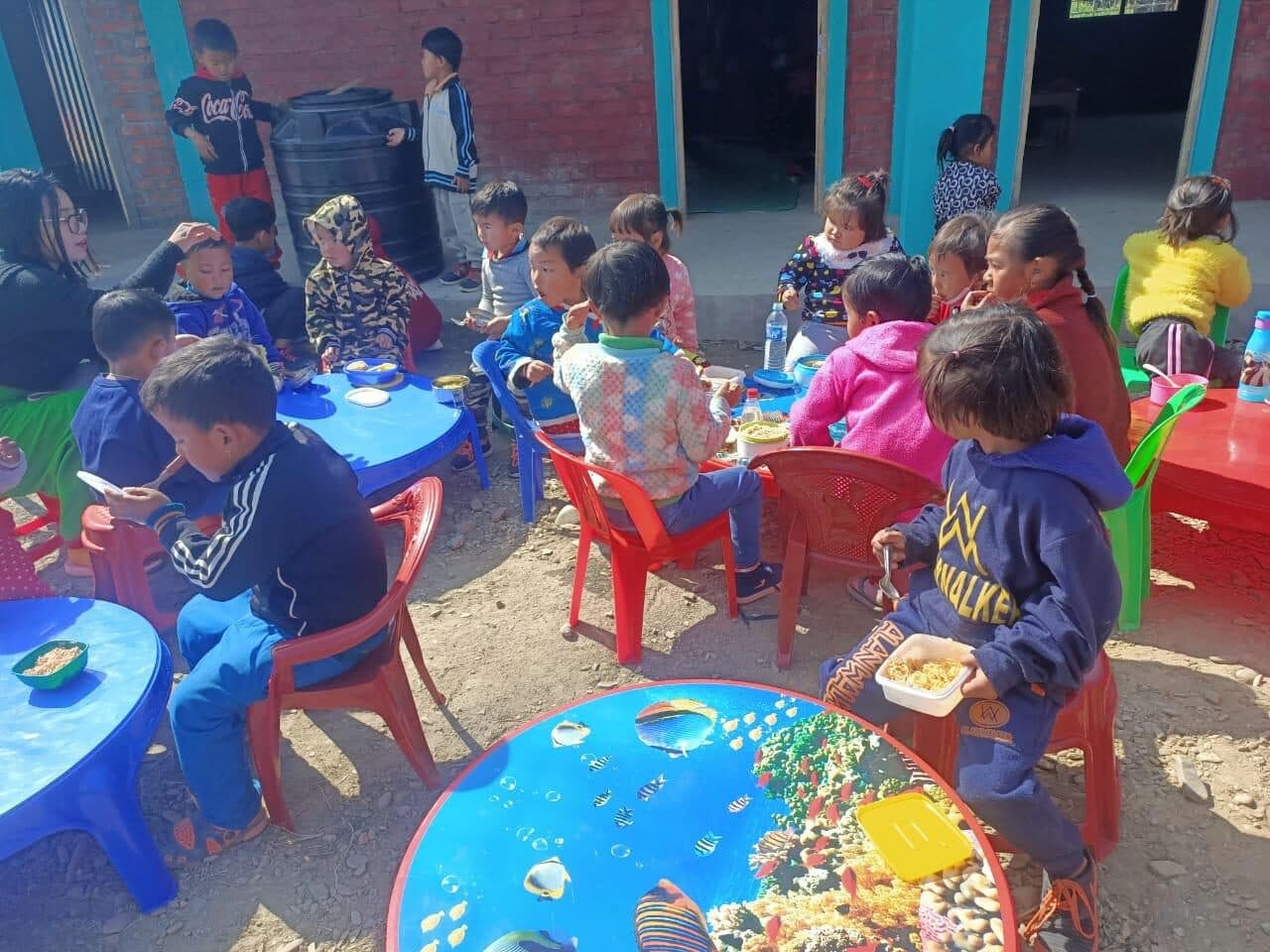 Young children eating together during the nutrition programme