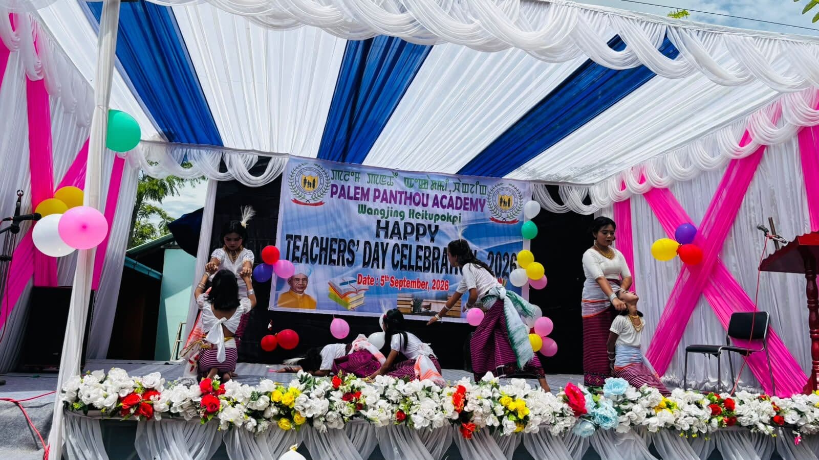 Performers lined up on the flower-decked stage