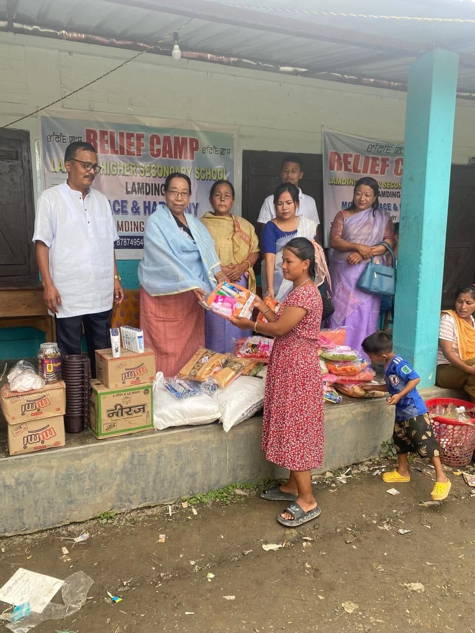A woman receiving a relief package at the camp distribution point