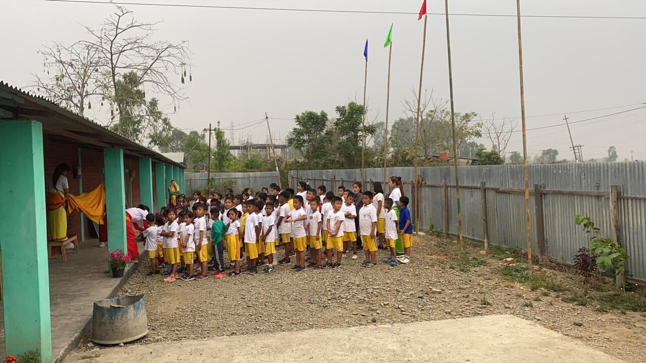 Children lined up in the schoolyard at the start of the day